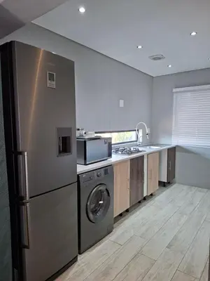 a kitchen with a stainless steel refrigerator and a dishwasher at Apartment 1 at CView in Pretoria