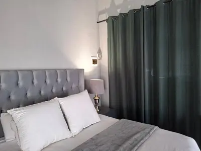 a bedroom with a bed with a green curtain at Apartment 1 at CView in Pretoria