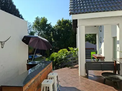 a patio with an umbrella and a table and chairs at Apartment 1 at CView in Pretoria