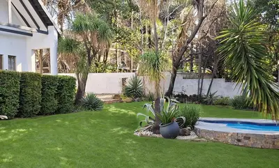 a yard with a swimming pool and palm trees at Apartment 1 at CView in Pretoria