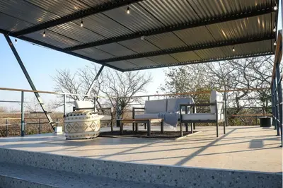 a pergola with two chairs and a table on a patio at Amani Luxury Villa Marloth Park in Marloth Park