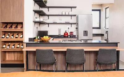 a kitchen with a counter with four chairs at Amani Luxury Villa Marloth Park in Marloth Park
