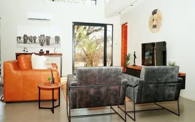 two chairs and a couch in a living room at Amani Luxury Villa Marloth Park in Marloth Park