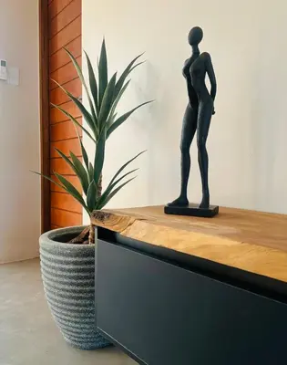 a statue of a man sitting on a counter next to a plant at Amani Luxury Villa Marloth Park in Marloth Park