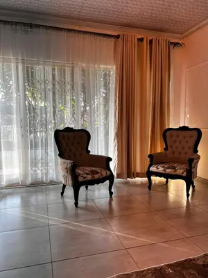 two chairs sitting in front of a large window at Luxury Airport Flatlet in Kempton Park
