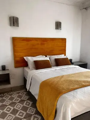a bedroom with two beds and a wooden headboard at Luxury Airport Flatlet in Kempton Park