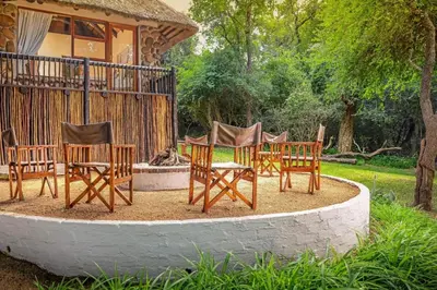 a group of chairs sitting in front of a house at Karongwe - Noka House in Hoedspruit