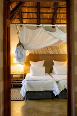 a bedroom with two beds with white sheets and pillows at Karongwe - Noka House in Hoedspruit