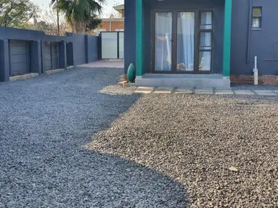 a house with a gravel yard in front of it at Stofberg Guest House in Brits