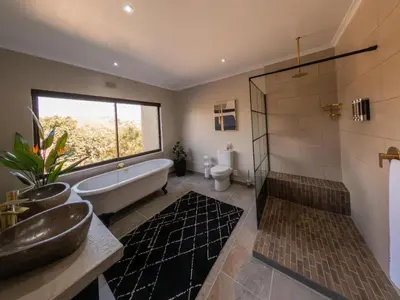 a bathroom with a tub and a sink and a shower at 8 On Penny Guesthouse in Nelspruit