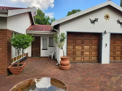 a house with a brick driveway and a garage at La Siesta in Pretoria