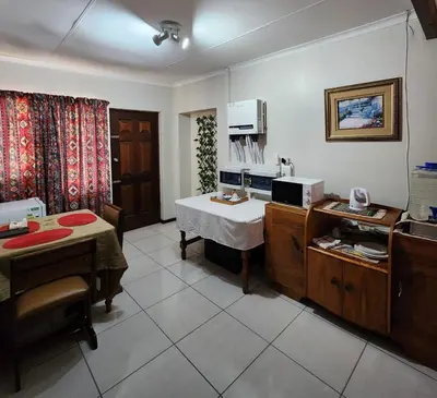 a room with a kitchen with a table and a microwave at La Siesta in Pretoria