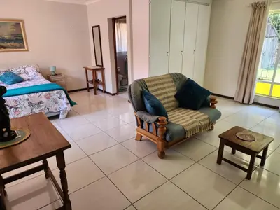 a living room with a chair and a bed at La Siesta in Pretoria