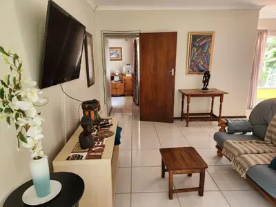 a living room with a couch and a tv at La Siesta in Pretoria
