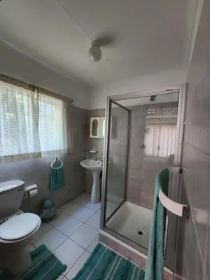 a bathroom with a shower and a toilet and a sink at La Siesta in Pretoria
