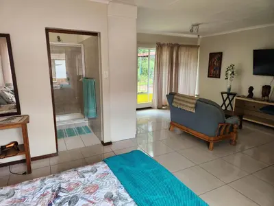 a living room with a couch and a television at La Siesta in Pretoria