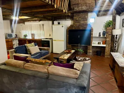a living room with a couch and a tv at The Treehouse in Pretoria