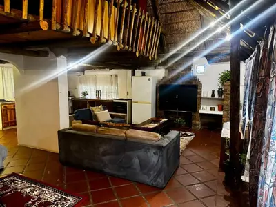 a living room with a couch and a television at The Treehouse in Pretoria