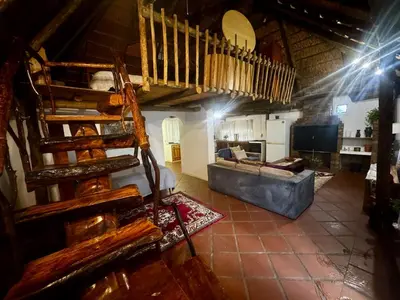 a living room with a staircase and a couch at The Treehouse in Pretoria