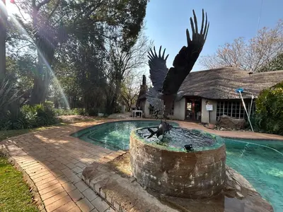 a statue of a monkey in a fountain next to a pool at Africa Skye Venue & Events in Pretoria