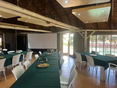 a conference room with green tables and white chairs at Africa Skye Venue & Events in Pretoria