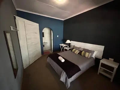 a bedroom with a large bed and a bathroom at Africa Skye Venue & Events in Pretoria