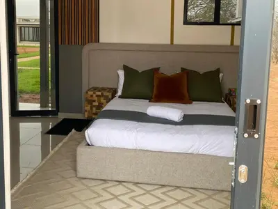 a bedroom with a bed with white sheets and pillows at Alldays Country Lodge in Alldays