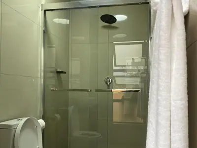 a glass shower door in a bathroom with a toilet at Alldays Country Lodge in Alldays