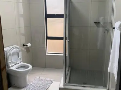 a bathroom with a toilet and a glass shower at Alldays Country Lodge in Alldays