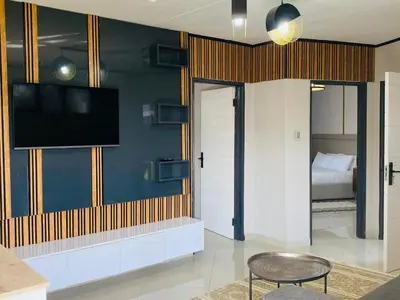 a living room with a tv on a wall at Alldays Country Lodge in Alldays