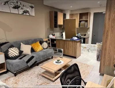 a living room with a couch and a kitchen at Home at 422Trilogy Menlyn Maine in Pretoria