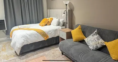 a bedroom with a bed and a couch at Home at 422Trilogy Menlyn Maine in Pretoria