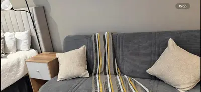 a couch with pillows on it next to a bed at Home at 422Trilogy Menlyn Maine in Pretoria