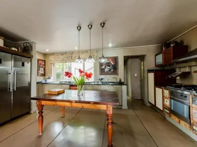 a kitchen with a table with a vase of flowers on it at La Serenita @ Migdash in Hartbeespoort