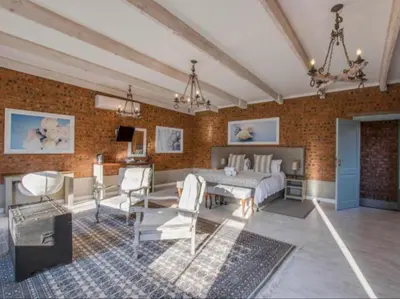a living room with a bed and a table and chairs at La Serenita @ Migdash in Hartbeespoort