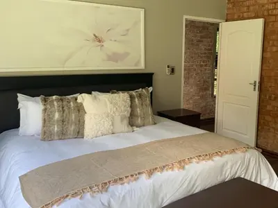 a bedroom with a large white bed with pillows at La Serenita @ Migdash in Hartbeespoort