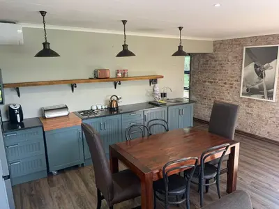 a kitchen with a wooden table and a dining room at La Serenita @ Migdash in Hartbeespoort