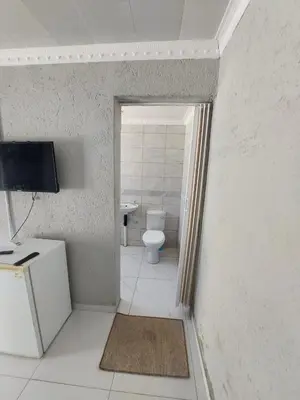 a bathroom with a toilet and a television in it at Baraba's guest house in Nelspruit