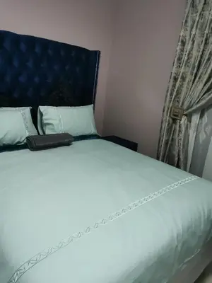 a bed with a blue headboard and a book on it at Blackpony Guesthouse in Kriel