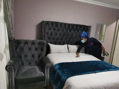 a man in a mask standing next to a bed at Blackpony Guesthouse in Kriel