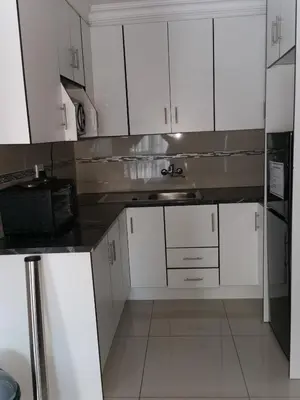 a kitchen with white cabinets and a sink at Blackpony Guesthouse in Kriel