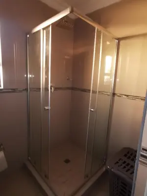a shower with a glass door in a bathroom at Blackpony Guesthouse in Kriel