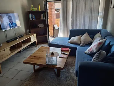 a living room with a blue couch and a coffee table at Pretoria east N4 rest and drive in Pretoria