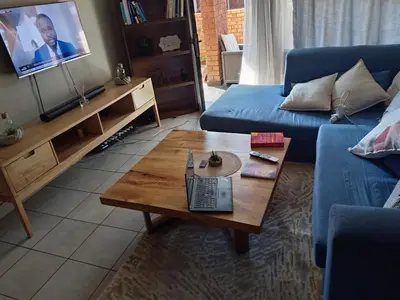 a living room with a blue couch and a coffee table at Pretoria east N4 rest and drive in Pretoria