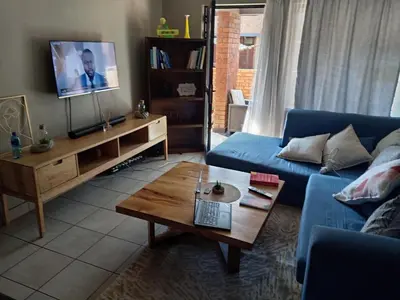 a living room with a blue couch and a coffee table at Pretoria east N4 rest and drive in Pretoria