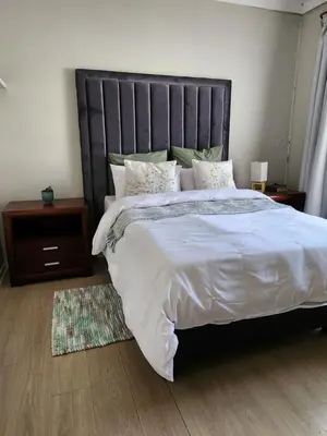 a bedroom with a large bed with white sheets and pillows at Pearl Palace in Polokwane
