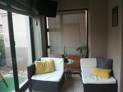 a living room with two chairs and a window at Pearl Palace in Polokwane