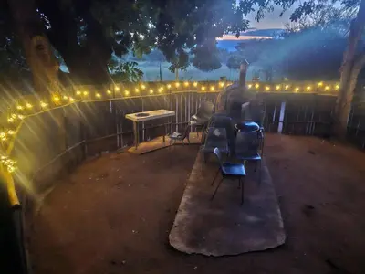 a fence with chairs and a table and lights at The Bushveld Jasmine in Mokopane