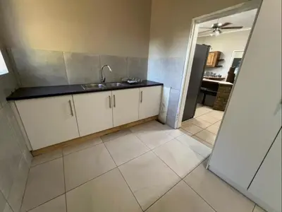 a kitchen with a sink and a tile floor at The Bushveld Jasmine in Mokopane