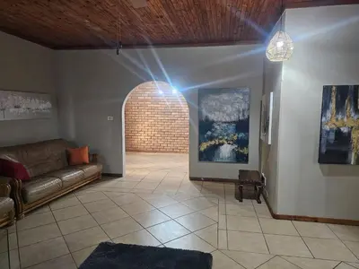 a living room with a couch and a brick wall at The Bushveld Jasmine in Mokopane